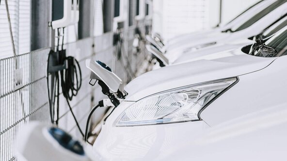 Mehrere weiße Firmenfahrzeuge sind an Wallbox angeschlossen