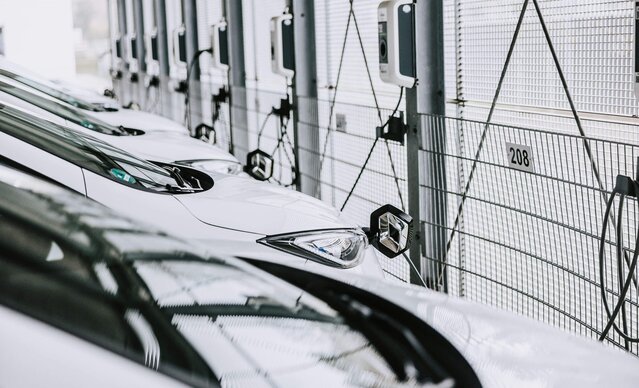 Mehrere weiße Firmenfahrzeuge sind an Wallbox angeschlossen