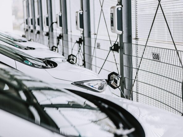 Mehrere weiße Firmenfahrzeuge sind an Wallbox angeschlossen