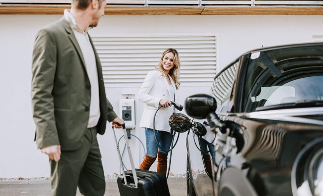Junges Paar lädt E-Auto an Hotel Wallbox
