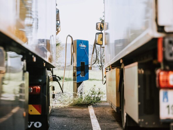 Zwei Lkws laden an einem Schnelllader