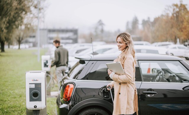 Mitarbeiterin lädt ihr Auto an einer Mitarbeiterladestation