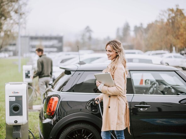 Mitarbeiterin lädt ihr Auto an einer Mitarbeiterladestation