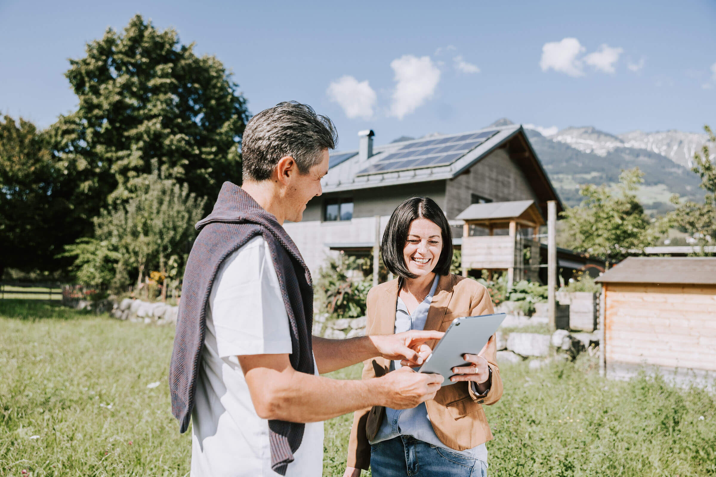 Mann zeigt Frau die eingespeiste Strommenge auf dem Tablet