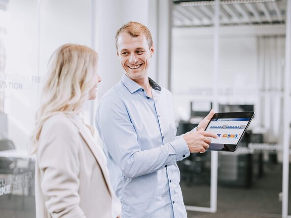 Mann zeigt Frau etwas auf dem Tablet