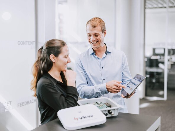 Mann zeigt Frau etwas auf dem Tablet