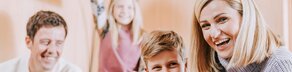 Familie sitzt auf Couch und spielt Playstation