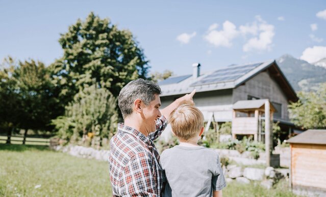 Vater zeigt seinem Sohn die PV Anlage auf dem Dach