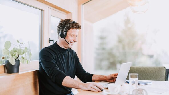 Mann telefoniert mit Handy an Esstisch