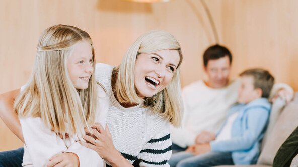 Familie sitzt auf Couch in Wohnzimmer
