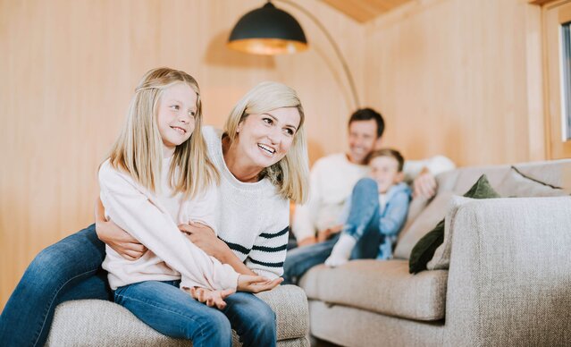 Familie sitzt auf Couch in Wohnzimmer