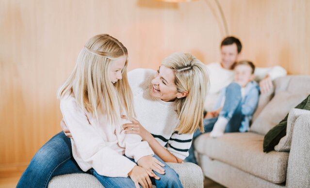 Familie sitzt auf Couch in Wohnzimmer