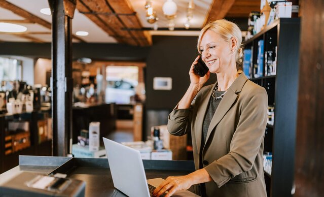 Ladenbesitzerin telefoniert in ihrem Geschäft