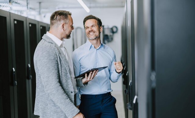 Unternehmer zeigt Kundenbetreuer seinen Serverschrank
