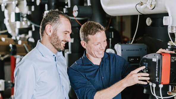 Ein Mann zeigt einem anderen die Heizung