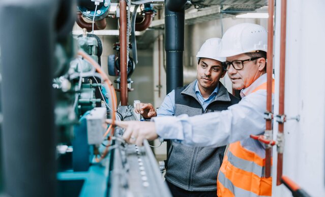 Ein Mann zeigt einem anderen die Heizung